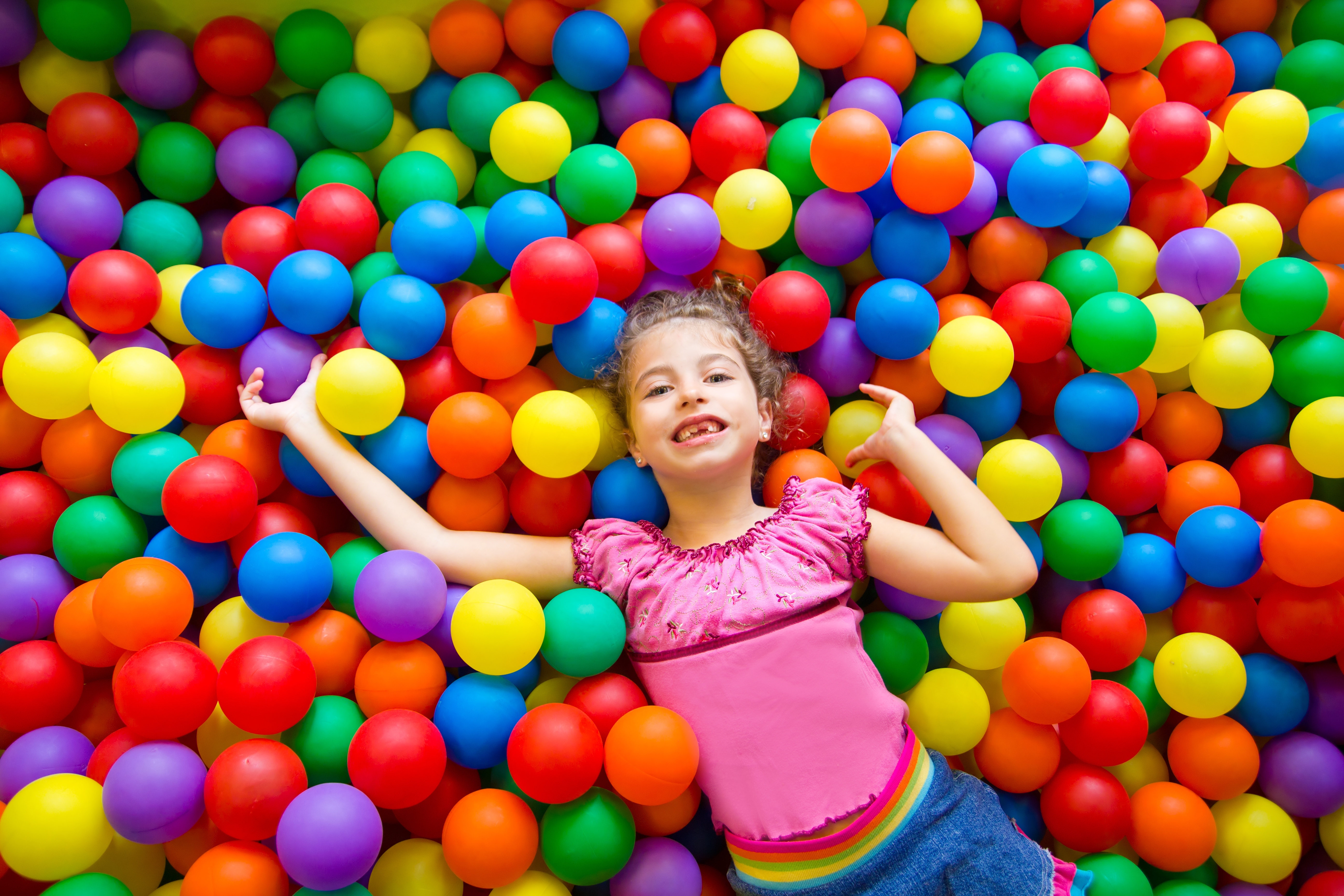 girl playing in a ballpit
